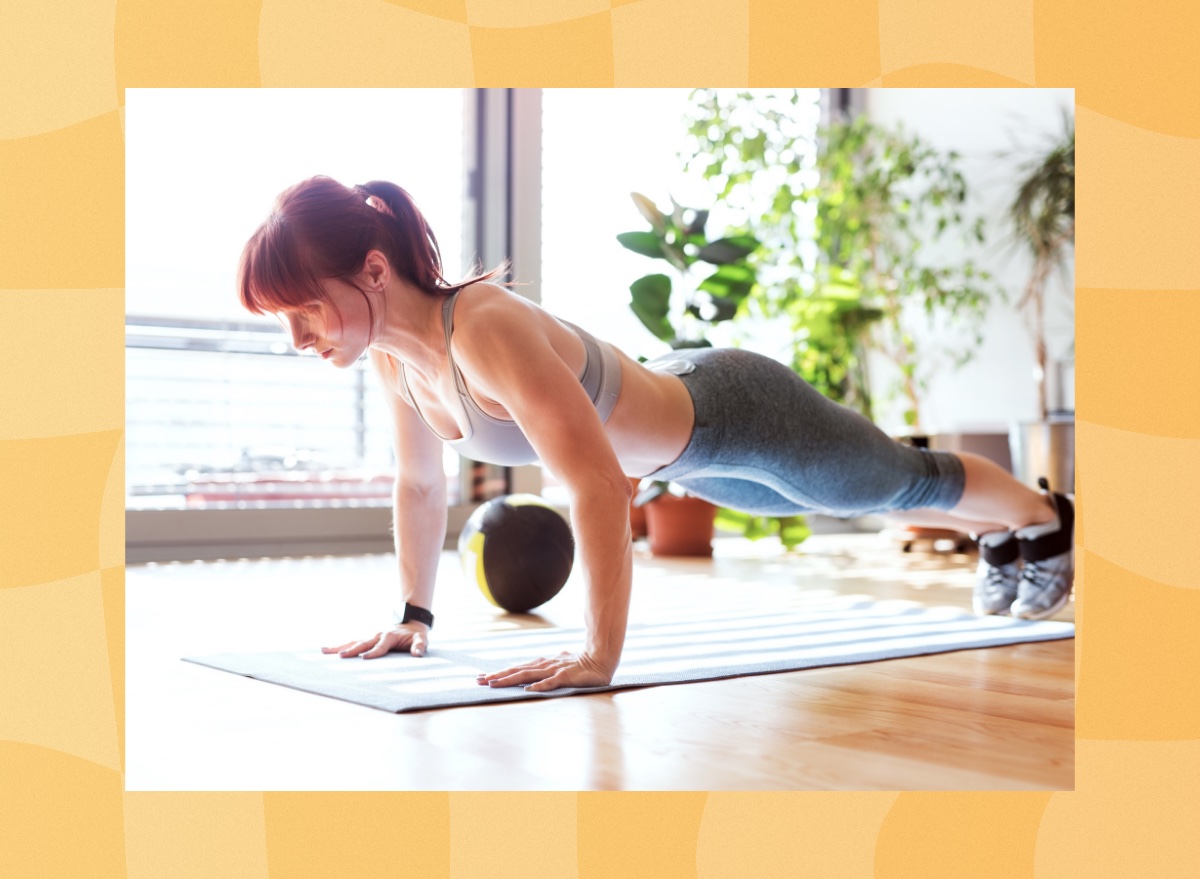 fit woman doing pushup exercise in bright living space