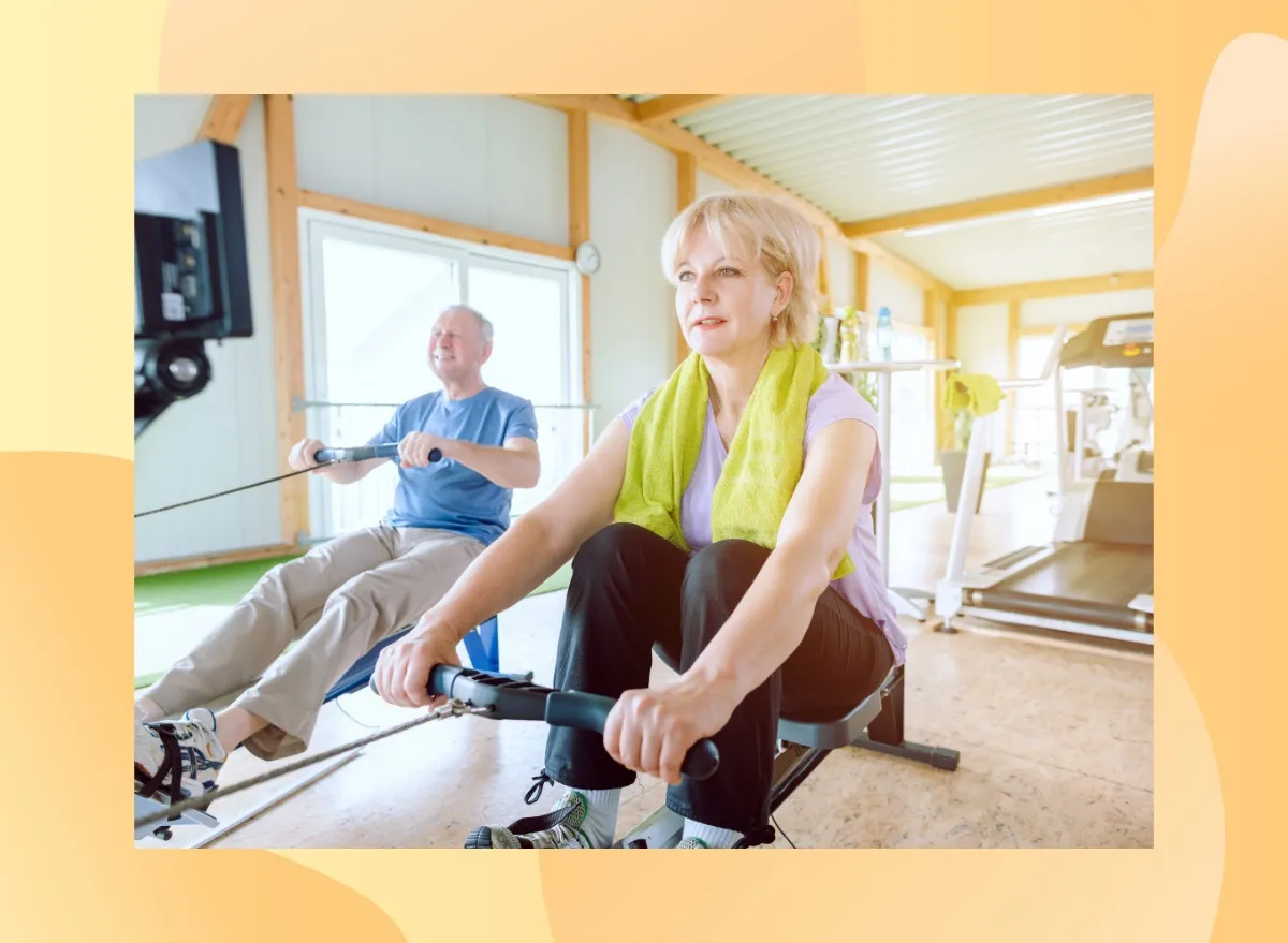 mature couple using rowing machines in bright gym