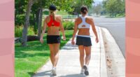 female friends walking outdoors on sidewalk for exercise on sunny day