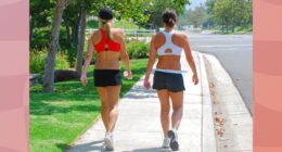 female friends walking outdoors on sidewalk for exercise on sunny day