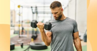 fit, muscular man lifting a dumbbell at outdoor gym