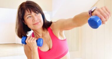 mature woman with dumbbells performing a breast lift workout