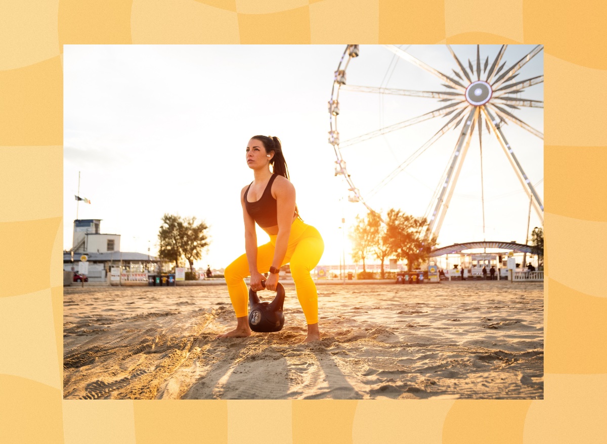 woman doing kettlebell squat exercise on the beach