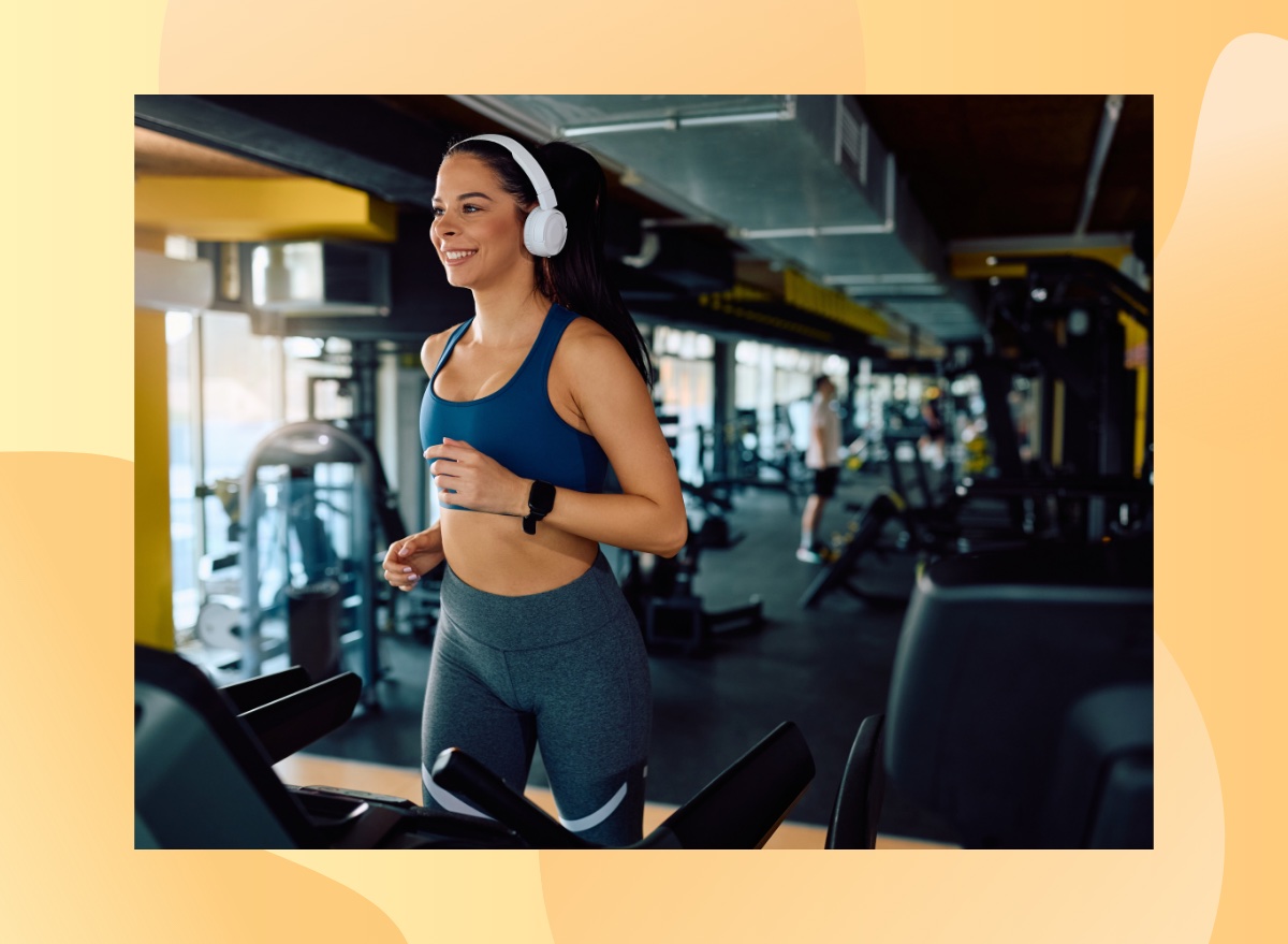 happy brunette woman running on the treadmill at the gym