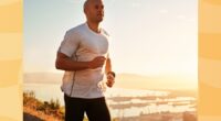 fit man jogging or running on a hilltop road at sunset