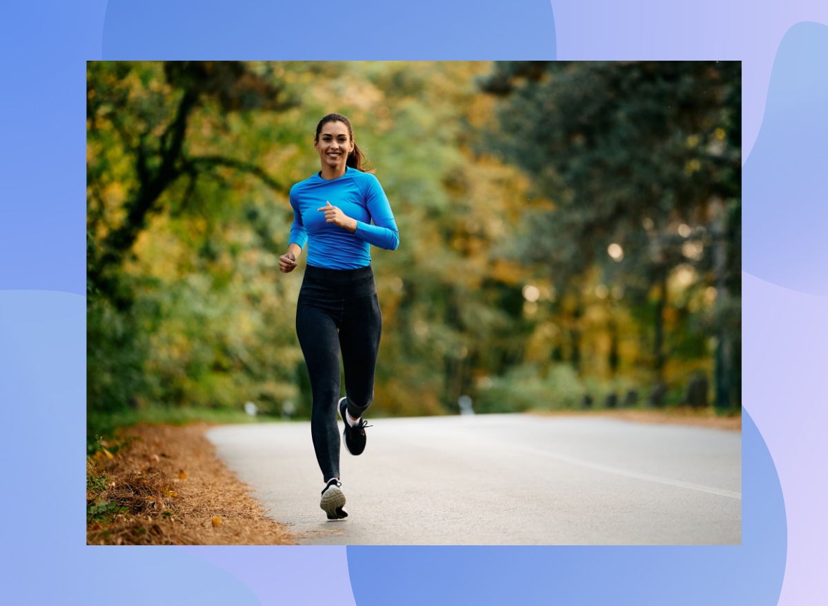 fit brunette woman running outdoors on street on brisk fall day