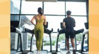 fit couple treadmill walking at the gym in front of windows