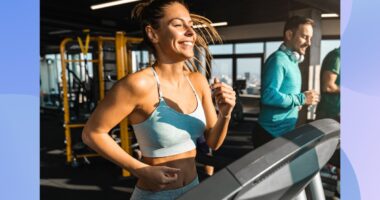 happy, fit woman running on treadmill at the gym