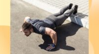 fit, muscular man doing feet-elevated pushups outdoors