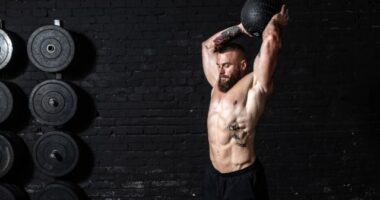 muscular man medicine ball slam, concept of ab workouts for men