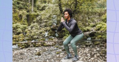 focused, mature woman doing squats while on nature hike