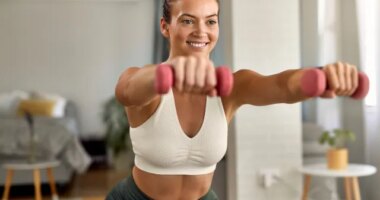 fit woman doing hourglass body workout at home, bright living room