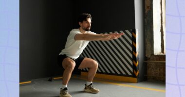 man doing squats at the gym