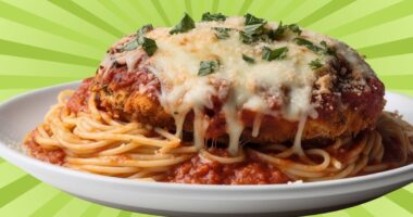 A plate of chicken parmesan over spaghetti set against a colorful background.