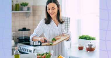 happy woman preparing healthy salad in bright kitchen