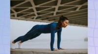 fit, focused brunette woman doing pushups outdoors under bridge