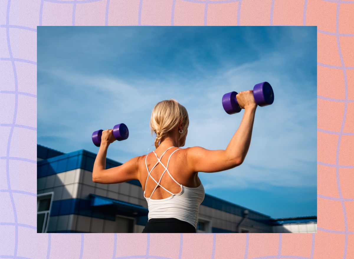 back view of fit blonde woman doing dumbbell press exercise outdoors in sunshine