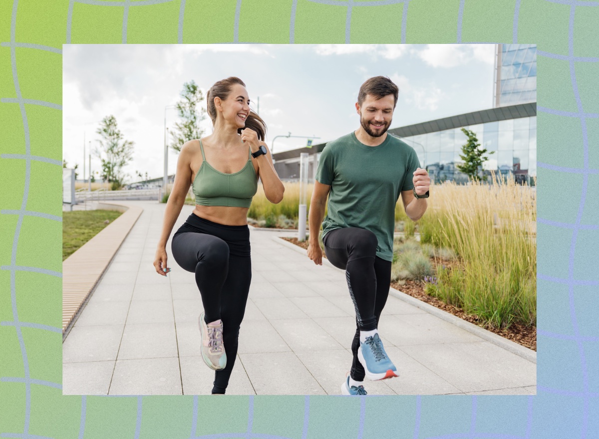 fit couple doing high knees exercise outdoors on paved walkway