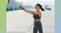 fit woman doing kettlebell swing exercise outdoors