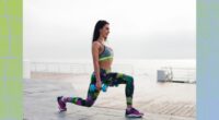 fit brunette woman doing dumbbell walking lunges on boardwalk by the beach on a cloudy day