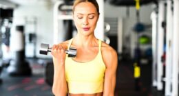 fit woman doing bicep curls demonstrating strength exercises for arm cellulite