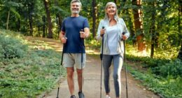 happy, mature couple doing Nordic walking on hiking trail