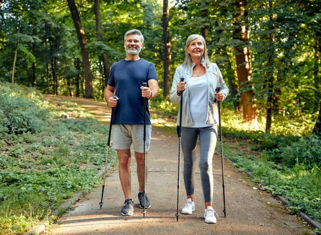 happy, mature couple doing Nordic walking on hiking trail