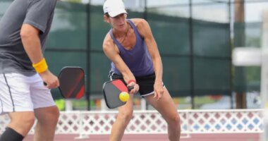 older couple playing a game of pickleball