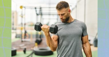 fit, muscular man doing bicep curls at an outdoor gym