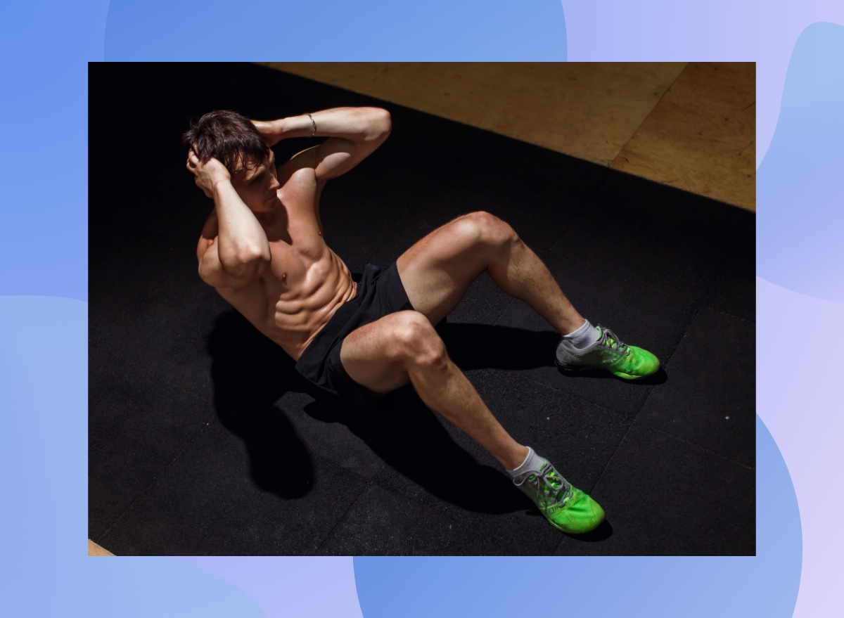 muscular man doing crunches on black workout mat