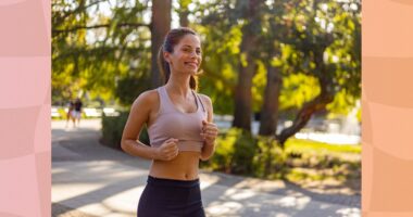 happy brunette woman doing light jogging in a park on a sunny day