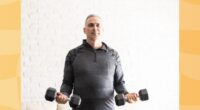 middle-aged man doing a bicep curl exercise with dumbbells in bright living space