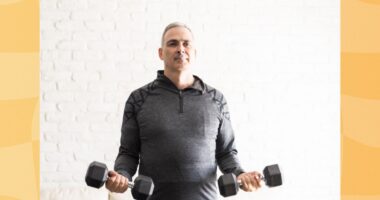 middle-aged man doing a bicep curl exercise with dumbbells in bright living space