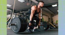 fit, muscular man doing a barbell deadlift with heavy weights at the gym