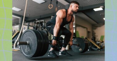 fit, muscular man doing a barbell deadlift with heavy weights at the gym