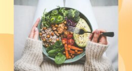 close-up of woman holding a healthy dinner plate filled with grains and vegetables