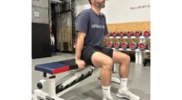 trainer setting up for a tricep dip on bench