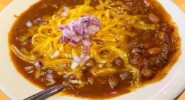 A bowl of chili from Texas Roadhouse set against a vibrant background