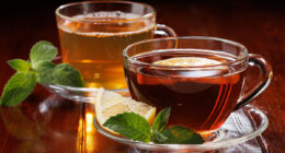 Hot green tea with mint and black tea with lemon and mint in glass cups. Side view. Selective focus.