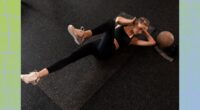 fit woman doing bicycle crunches on black yoga mat in dark gym setting