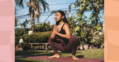 peaceful brunette woman doing yogi squat on mat outdoors in yard on sunny day