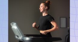 fit, focused brunette woman in black t-shirt and leggings walking on treadmill