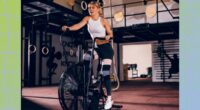 blonde woman doing intense assault bike workout at the gym