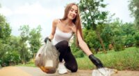 woman picking up trash while plogging