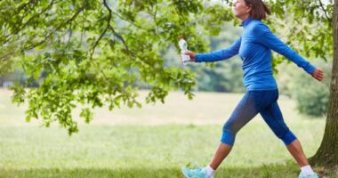 mature woman on brisk walk on trails, concept of low-impact exercises to melt belly fat