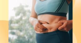 close-up of woman in athletic outfit holding excess belly fat