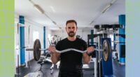 fit, focused man doing a barbell bicep curl at the gym