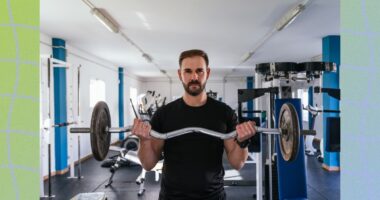 fit, focused man doing a barbell bicep curl at the gym