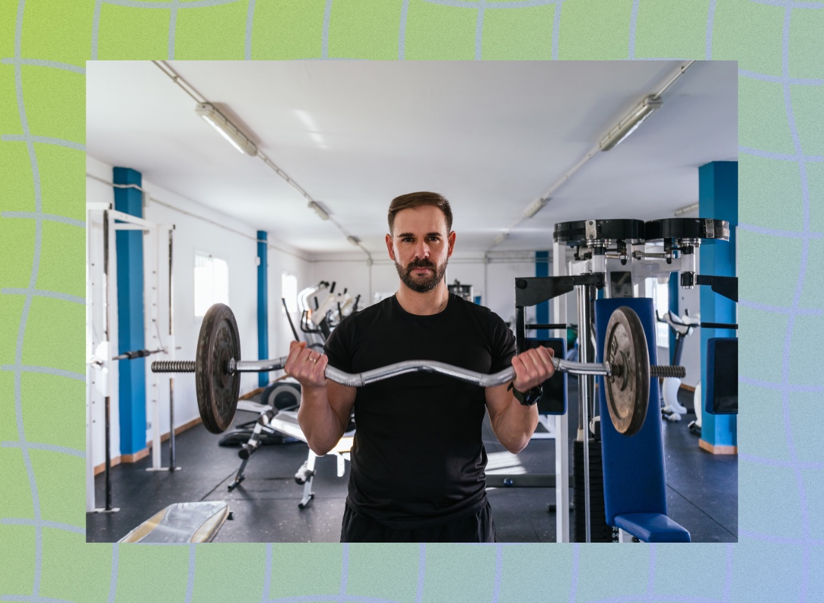 fit, focused man doing a barbell bicep curl at the gym