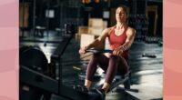 fit, focused brunette woman using a rowing machine at the gym